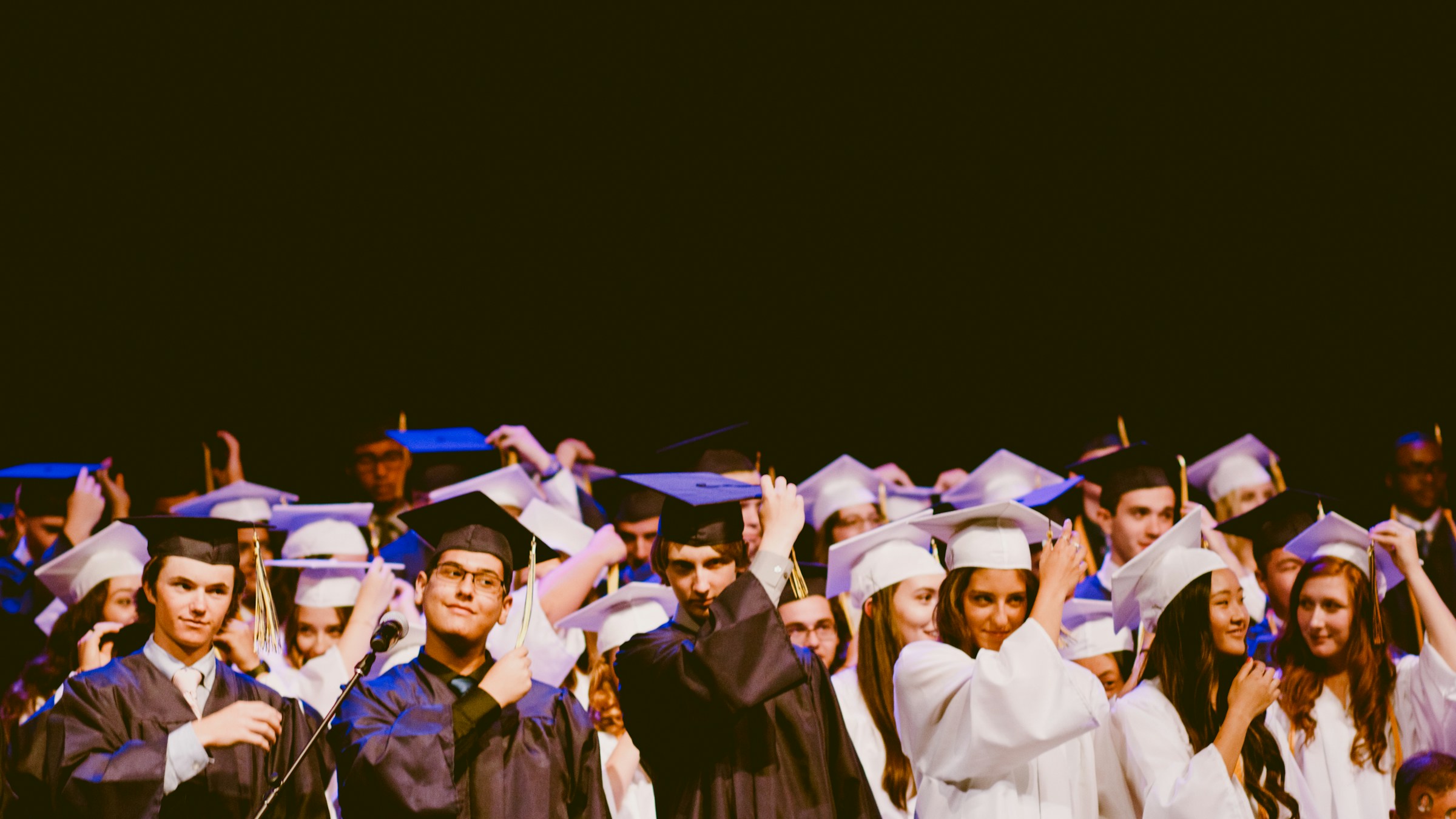 A group of graduates in caps and gowns celebrating together